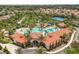 Aerial view of a community pool with lush landscaping, palm trees and clubhouse at 7041 Oakwood St, Davenport, FL 33837
