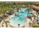 Aerial view of a community pool with a splash zone, palm trees and waterslides at 7041 Oakwood St, Davenport, FL 33837