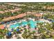 Aerial view of a large community pool with blue umbrellas, palm trees and lounge chairs at 7041 Oakwood St, Davenport, FL 33837
