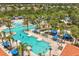 Aerial view of community pool with swimming, sunbathing and palm tree landscaping at 7041 Oakwood St, Davenport, FL 33837