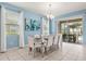 Dining room with a modern light fixture, with the view to the screened in pool area at 7041 Oakwood St, Davenport, FL 33837
