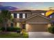 Charming two-story home with a well-maintained lawn and a two-car garage at 7041 Oakwood St, Davenport, FL 33837