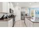 Modern kitchen with granite counters, white cabinets, and stainless steel appliances at 7041 Oakwood St, Davenport, FL 33837