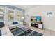 Bright living room with large TV and cozy white sectional sofa at 7041 Oakwood St, Davenport, FL 33837