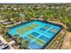 Aerial view of blue and green tennis and pickleball courts in a gated community at 7041 Oakwood St, Davenport, FL 33837