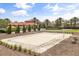 A pristine sand volleyball court surrounded by manicured landscaping and palm trees, perfect for outdoor recreation and enjoyment at 7041 Oakwood St, Davenport, FL 33837