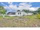 View of the backyard with grassy area, tree stump, and manicured landscaping at 750 Polo Park Blvd, Davenport, FL 33897