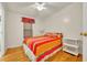 Bedroom with colorful bedding, a ceiling fan, wood flooring, and a small window at 750 Polo Park Blvd, Davenport, FL 33897