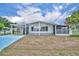 Charming single-story home featuring a carport, screened porch, and a well-maintained lawn under a sunny sky at 750 Polo Park Blvd, Davenport, FL 33897