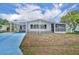 Charming single-story home featuring a carport, screened porch, and a well-maintained lawn under a sunny sky at 750 Polo Park Blvd, Davenport, FL 33897