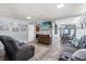 Comfortable living room featuring gray wood floors and a modern entertainment area with a flat-screen TV at 793 Greenway Pl, Daytona Beach, FL 32114