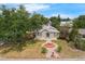 An aerial view of a home showing its charming landscape, a decorative fountain feature, and surrounding trees at 803 Jersey Ave, St Cloud, FL 34769