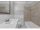 Bright bathroom featuring a tub with tiled surround, a modern sink with vanity, and black and white tiled floors at 803 Jersey Ave, St Cloud, FL 34769
