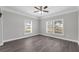 Bright bedroom featuring modern flooring, fresh paint, and plenty of natural light from two large windows at 803 Jersey Ave, St Cloud, FL 34769