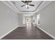 Bright and airy living room featuring a stylish tray ceiling, and hardwood flooring at 803 Jersey Ave, St Cloud, FL 34769