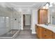 Bright bathroom featuring walk-in glass shower, wood cabinets, and access to the walk-in closet at 803 Jersey Ave, St Cloud, FL 34769