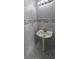 Bathroom featuring a pedestal sink, a brass faucet, and light grey marble tile walls at 8612 Valley Ridge Ct, Orlando, FL 32818