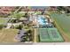 Community aerial view featuring a pool, sport courts, parking, and adjacent buildings at 8919 Bismarck Palm Rd, Kissimmee, FL 34747
