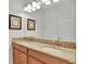 Bathroom vanity with dual sinks, granite countertop and framed mirror at 8919 Bismarck Palm Rd, Kissimmee, FL 34747
