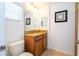Well-lit bathroom with a granite countertop, wood cabinets, and neutral-toned walls at 8919 Bismarck Palm Rd, Kissimmee, FL 34747