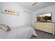 Comfortable bedroom with a cozy bed, a dresser with a TV, and closet space at 8919 Bismarck Palm Rd, Kissimmee, FL 34747