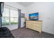 A well-lit bedroom with a dresser with a TV, large window, and ample space at 8919 Bismarck Palm Rd, Kissimmee, FL 34747