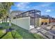 Exterior view of the home showcases the side yard, screened in pool, and paver sidewalk to the entrance gate at 8919 Bismarck Palm Rd, Kissimmee, FL 34747