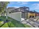 Exterior view of the home showcases the side yard, screened in pool, and paver sidewalk to the entrance gate at 8919 Bismarck Palm Rd, Kissimmee, FL 34747