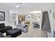 Open-concept living space featuring tile floors, staircase, and kitchen with breakfast bar at 8919 Bismarck Palm Rd, Kissimmee, FL 34747