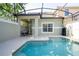 Sparkling in-ground pool with a screened enclosure and a shaded patio area with seating at 8919 Bismarck Palm Rd, Kissimmee, FL 34747
