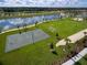 Aerial view showcases community amenities, including a sports field, pool, splashpad, and stunning lake with fountain views at 8940 Coconut Breeze Dr, Kissimmee, FL 34747
