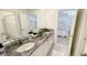Bathroom featuring dual sinks, elegant granite countertops, and tile floors at 8940 Coconut Breeze Dr, Kissimmee, FL 34747