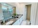 This bathroom features a double vanity with a marble countertop and a shower with glass doors at 8940 Coconut Breeze Dr, Kissimmee, FL 34747