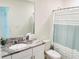 Bright bathroom features a vanity with granite countertops, ample mirror space, and a shower/tub combo at 8940 Coconut Breeze Dr, Kissimmee, FL 34747