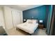 Stylish bedroom with a modern accent wall, plush bedding, and well-appointed bedside tables with lamps at 8940 Coconut Breeze Dr, Kissimmee, FL 34747
