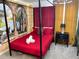 Bright bedroom featuring a four-poster bed with a mural backdrop and a themed color scheme at 8940 Coconut Breeze Dr, Kissimmee, FL 34747