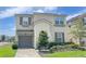 Charming two-story home with a well-maintained lawn and neutral-colored stucco exterior at 8940 Coconut Breeze Dr, Kissimmee, FL 34747