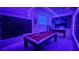 A futuristic game room illuminated with neon lights, pool table, and murals for entertainment at 8940 Coconut Breeze Dr, Kissimmee, FL 34747