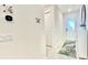 Well-lit hallway with a decorative rug, wall decor, light switches, and a door with a glass window at 8940 Coconut Breeze Dr, Kissimmee, FL 34747