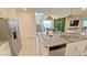 Open kitchen with island, stainless steel fridge, and view into the dining and living spaces at 8940 Coconut Breeze Dr, Kissimmee, FL 34747