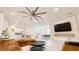 Contemporary living area with a large sectional sofa, modern ceiling fan, and an open floor plan to the kitchen at 8940 Coconut Breeze Dr, Kissimmee, FL 34747