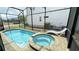 Relax by the screened in pool with a connecting jacuzzi and brick pavers, making the backyard into a personal oasis at 8940 Coconut Breeze Dr, Kissimmee, FL 34747