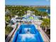Community water park with wave simulator, splash pad, pools, and lounge seating surrounded by tropical landscaping at 8940 Coconut Breeze Dr, Kissimmee, FL 34747