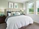 Serene main bedroom with calming colors, plush bedding, and natural light from the large window at 903 Donahue Pass, Lake Hamilton, FL 33851
