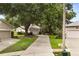 View of home flanked by mature shade trees, with a curving driveway, and manicured lawn at 926 Ridgeland Ct, Apopka, FL 32712