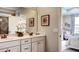A well-lit bathroom features double sinks, decorative accents, and a view into the bedroom, offering a spa-like feel at 11003 Hollow Bay Dr, Winter Garden, FL 34787