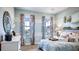 Bright bedroom featuring large windows with floral drapes and a comfortable bed, creating a cozy and inviting space at 11003 Hollow Bay Dr, Winter Garden, FL 34787