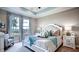 Tranquil bedroom with tray ceiling, large window, and a comfortable bed adorned with stylish bedding and decor at 11003 Hollow Bay Dr, Winter Garden, FL 34787