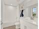A clean white bathroom features a tub shower with white tile and a white sink with modern chrome fixtures at 11057 Hollow Bay Dr, Winter Garden, FL 34787