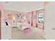 Well-lit pink bedroom with carpet, two large windows with pink curtains, and white bedside tables and decor at 11057 Hollow Bay Dr, Winter Garden, FL 34787